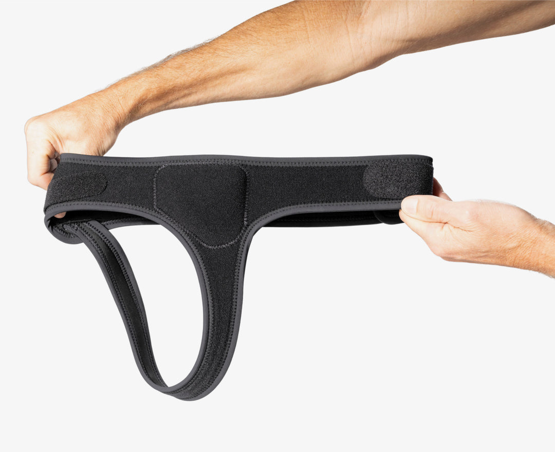 Hands holding minimalist single side hernia belt