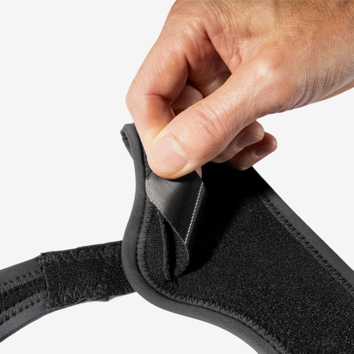 Hand showing minimalist hernia belt is fully adjustable 