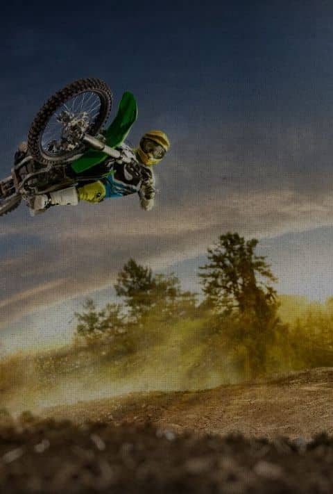 dirt bike rider wearing hernia belt up in the air on bike