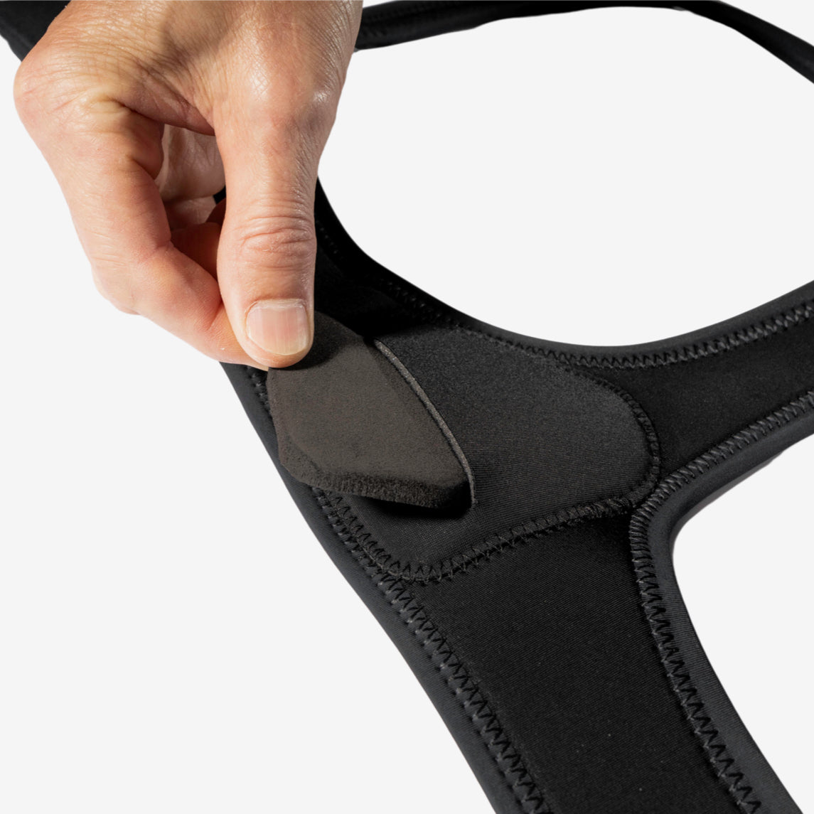 Hand showing the minimalist single hernia belt pad is interchangeable